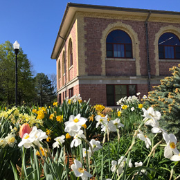 the exterior of a building on the Dakota State campus with some white flowers in front